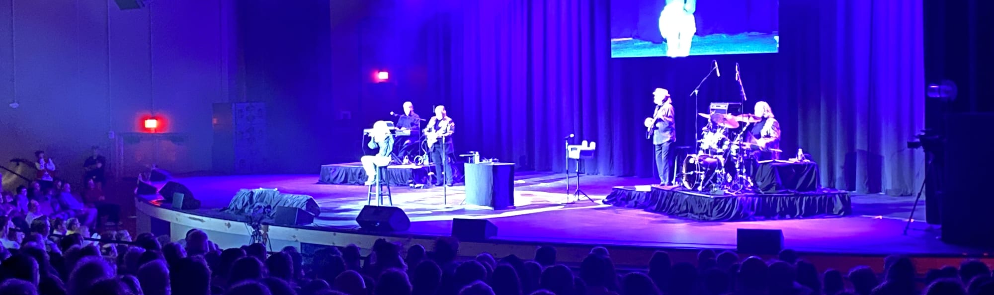 signer on stage in chair washed out by the lights Des Moines